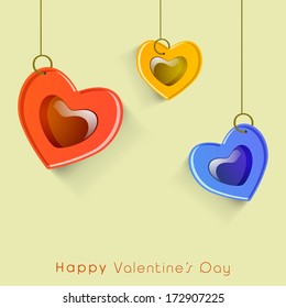 Hanging glossy heart shape on green background for Happy Valentines Day concept. 