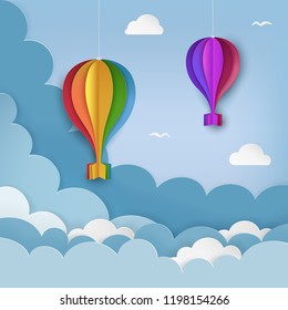 Hanging paper craft hot air balloons, flying birds, clouds on the daytime sky background. Cloudy sky background. Minimal summertime scene. Paper hot air balloon garland with bows. Vector Illustration.