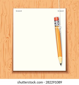 Hanging pencil by the paper sheet on the wooden board.