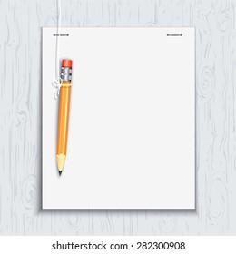 Hanging pencil by the paper sheet on the wooden board.