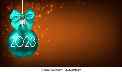 Hanging realistic green Christmas bauble with 2023 sign on orange background. Space for text.