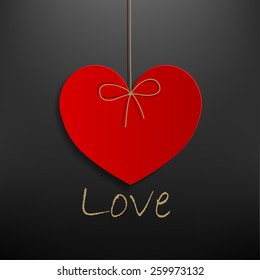 hanging red heart  on dark gray background.