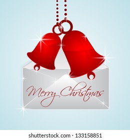 Hanging red jingle bells out of envelope with Merry Christmas message