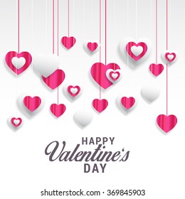 Hanging shiny pink heart on white background.