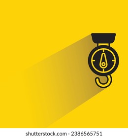hanging weight scale with shadow on yellow background