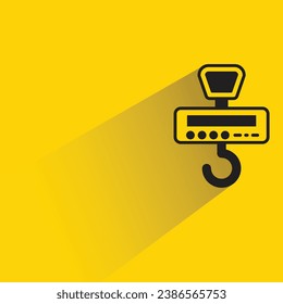 hanging weight scale with shadow on yellow background