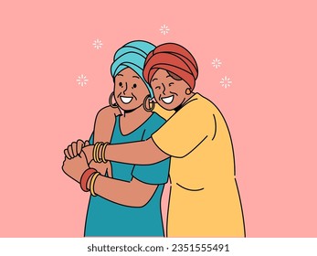 Happy adult mother and daughter in national african clothes embrace together, rejoicing at meeting. Mature woman hugging elderly mother, feeling gratitude and recognition for good upbringing