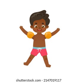 Happy african american boy jumping on the summer vacations. Adorable kid in inflatable armbands.