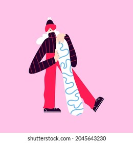 Happy alpine skier with a snowboard. A woman in ski goggles and warm clothes holds a snowboard. Smiling girl in a ski suit posing for a photo on a pink background.