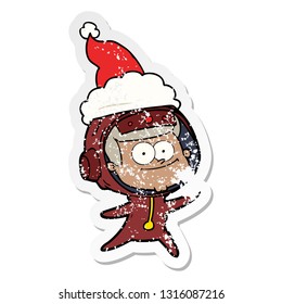 happy astronaut hand drawn distressed sticker cartoon of a wearing santa hat