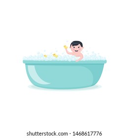 Happy baby taking a bath with yellow ducks, smiling boy in bubble bath, kid playing in the foam tub