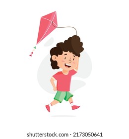 Happy boy playing kite while running at summer holiday