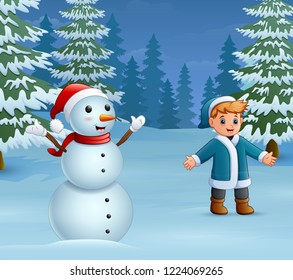 Happy boy playing with a snowman in winter