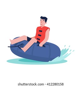 Happy boy is riding on an inflatable tube on the water.  Perfect summer vacation. Summer water sports. 