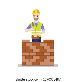 A happy builder in a helmet lays down a brick wall with a trowel in his hand. Flat illustration on white background.