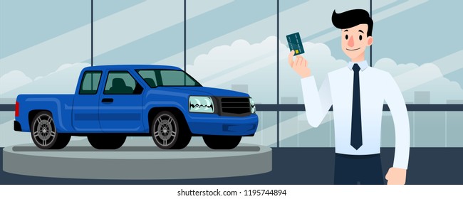 Happy businessman, seller stand and holding credit card in front of blue pickup truck that parking in large showroom in the city.