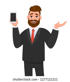 Happy businessman showing or holding smart phone, mobile, cell phone in hand and gesturing hand to copy space side away. Human emotion and body language concept illustration in vector cartoon.