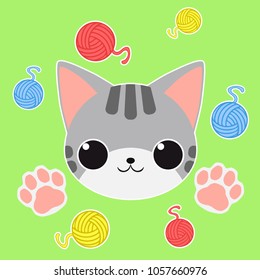 Happy cartoon kitty face on green background with colorful wool balls