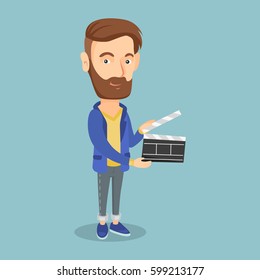 Happy caucasian man working with a clapperboard. Smiling hipster man holding an open clapperboard. Cheerful man holding blank movie clapperboard. Vector flat design illustration. Square layout.