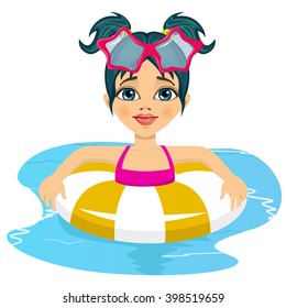 Happy child girl swimming in pool with inflatable ring