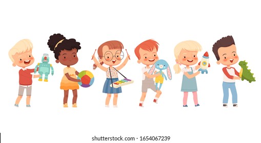 Happy children play with different toys, hold them in their hands. Funny kids of different nationalities with favorite toys.