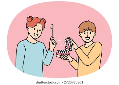 Los niños felices muestran reglas para cepillarse los dientes y usar el cepillo dental para eliminar las bacterias en la boca. Niño y niña aconsejan a sus compañeros a cuidar la salud dental de los dientes y las encías.