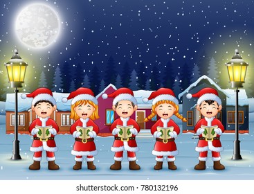 Happy children singing christmas carols in winter night landscape