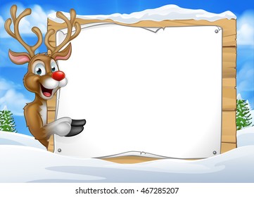 A happy Christmas Santas reindeer cartoon character in a winter scene peeking around pointing at a sign