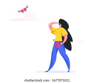 Feliz mujer contemporánea con control remoto manteniendo la mano cerca de la frente y mirando lejos con sonrisa mientras piloteaba modernos drones en la naturaleza