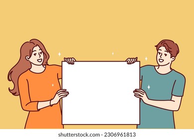 Happy couple with blank poster with copy space for your promotional offer or company logo. Man and woman show blank poster for application of information with announcement of favorable discounts