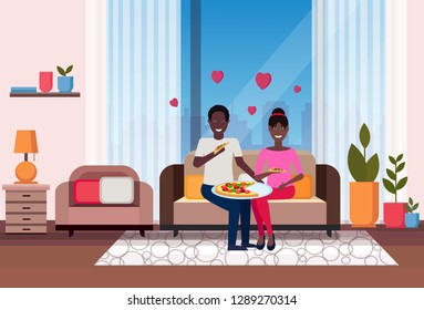 happy couple eating pizza african american man woman sitting on couch modern apartment home living room interior male female cartoon characters flat horizontal