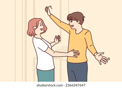 Happy couple embraces at meeting near entrance to house and rejoices at long-awaited date. Man returns from business trip and hugs wife or girlfriend, rejoicing in date after long separation.