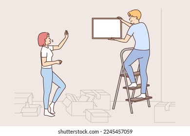 Happy couple hanging pictures on walls decorating house together. Man and woman decorate home with paintings settle in new shared dwelling. Vector illustration. 