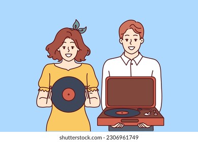 Happy couple with turntable and vinyl record invites you to retro party with jazz music. Young man and woman collecting vintage vinyl records with music from their favorite artists.