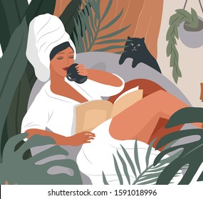 Happy cute girl with towel on head and in bathrobe, drinks coffeeor tea in morning after bathing, read the newspaper and resting with cat. Feminine Daily life by young woman with homeplant