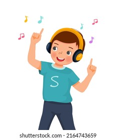 Happy cute little boy dancing while listening to music with headphone 