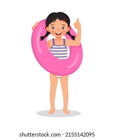 happy cute little girl with swimsuit holding inflatable rubber ring showing thumb up having fun on summer time