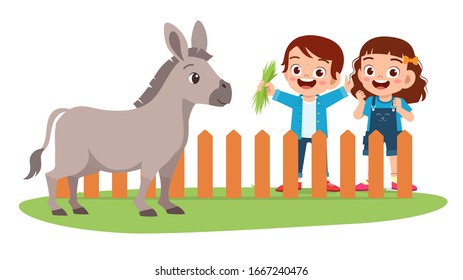 happy cute little kid boy and girl feed donkey