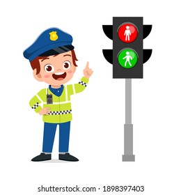 happy cute little kid boy wearing police uniform and stand beside traffic lamp