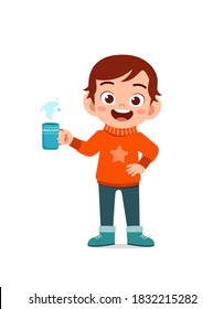 happy cute little kid drink hot chocolate in winter season. child drink milk wearing warm clothes