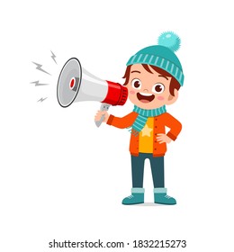happy cute little kid holding megaphone in winter season and wearing warm clothes