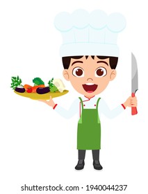 Happy cute smart kid boy chef character wearing chef outfit and holding plate with vegetables and cutter with cheerful expression