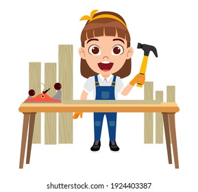 Feliz tierno carpintero infantil inteligente personaje de chica parado martillo al lado de la mesa con equipos y tablas de madera aisladas