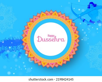 Happy Dussehra Lettering Over Mandala Frame With Lord Rama Taking An Aim Against Demon Ravana On Blue Bokeh Background.