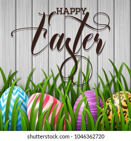 Happy Easter background with colored eggs in the grass on wood wall background