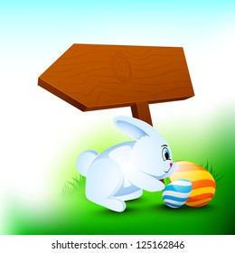 Fröhlicher Osterhintergrund mit Kaninchen, bemalten Eiern und hölzernem Zeichenbrett für Ihre Nachricht.