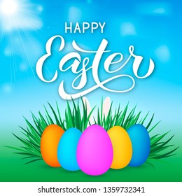 Happy Easter calligraphy lettering. Easter eggs on grass and bunny’s ears.  Spring holidays vector illustration. Easy to edit template for party invitation, typography poster, greeting card, banner.