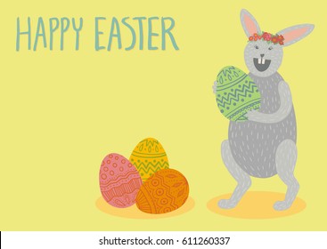 Happy Easter card. Cute grey bunny holding green decorated egg, laughing, wearing flower crown, standing. Pile of colorful eggs. Hand drawn lettering. Yellow background. A6, A5, A4, A3 horizontal size