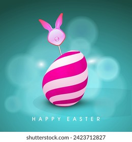 Happy Easter Celebration Concept with Bunny Ear Stick with Painted Egg on Blurred Effect Pastel Teal Background.