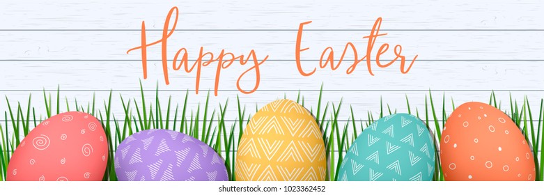Happy Easter. Easter colorful eggs in row on white wooden wooden Scandinavian background with herbs